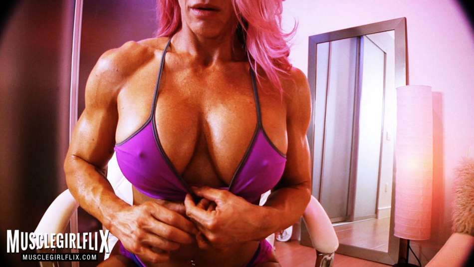 muscular female bodybuilder flexing on webcam